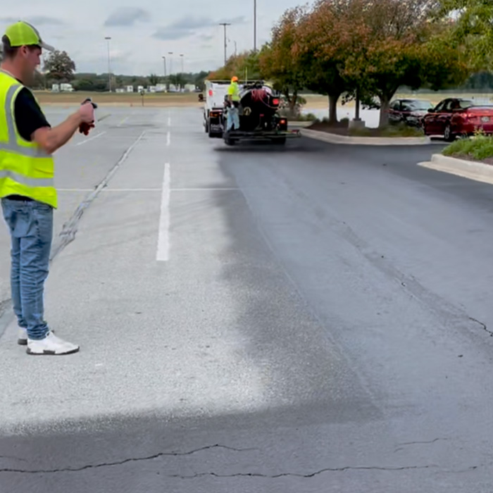 Workers fixing parking lot with machine