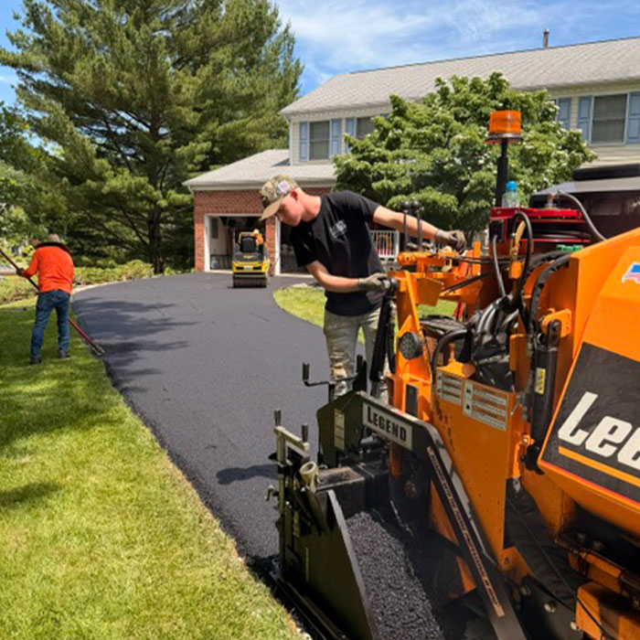 Workers fixing driveway with machine