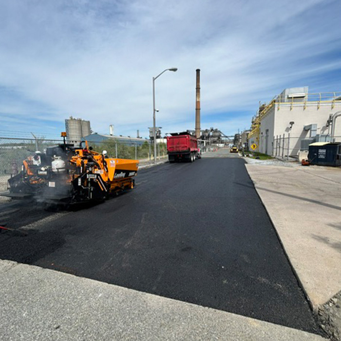 Workers fixing road with machine